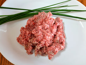 raw ground lamb on white plate with garnishes